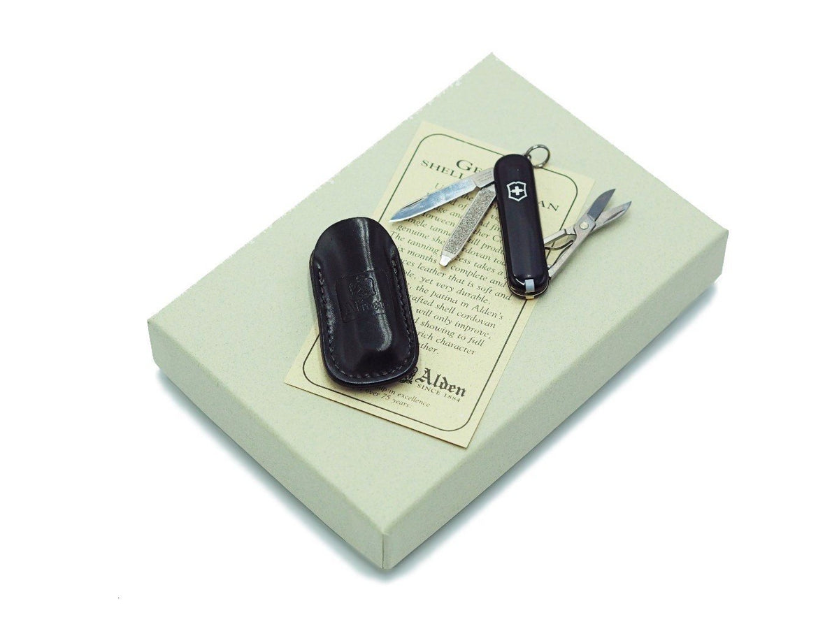 Swiss army knife and Alden black shell cordovan knife case on top of box
