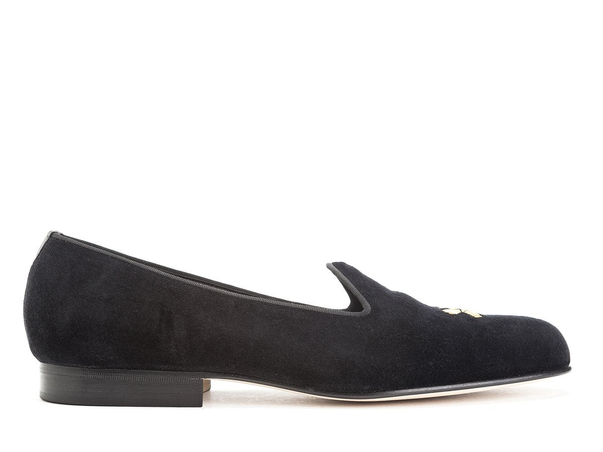 Side view of Edward Green Albert slippers in black velvet with hand embroidered gold Double Monk logo on toe
