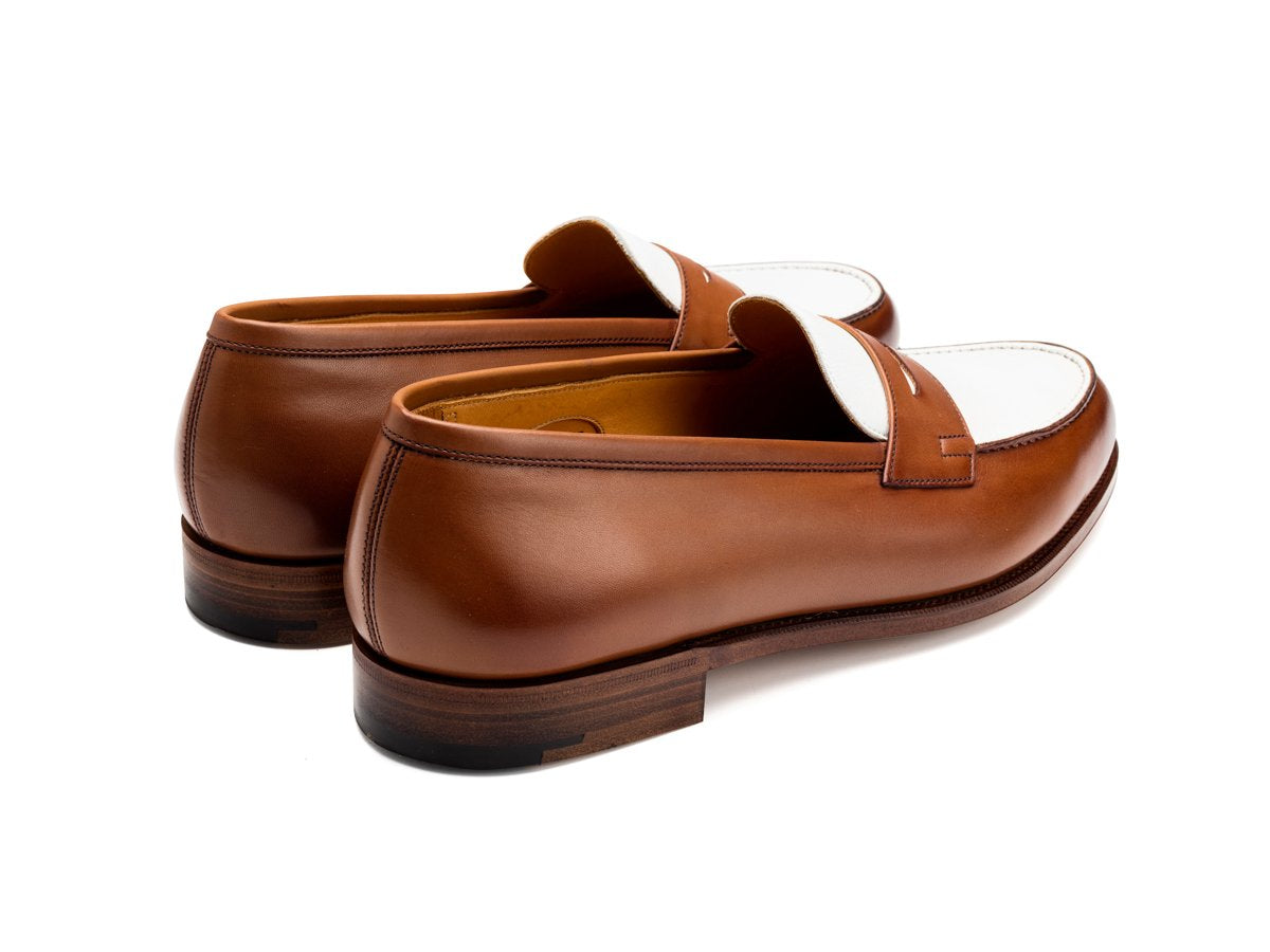 Back angle view of Edward Green Duke spectator penny loafers in hazel and white calf