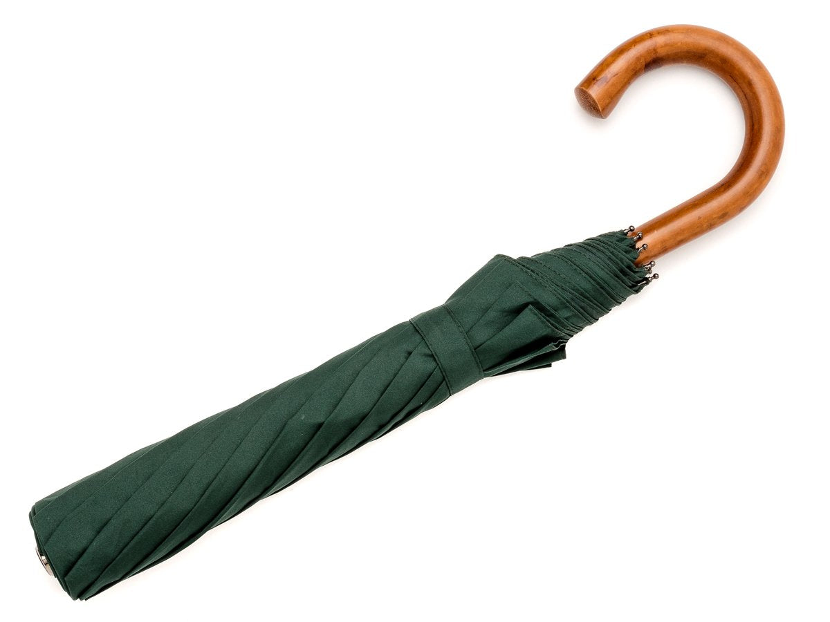 Full length view of malacca handle telescopic Fox Umbrella with dark green canopy