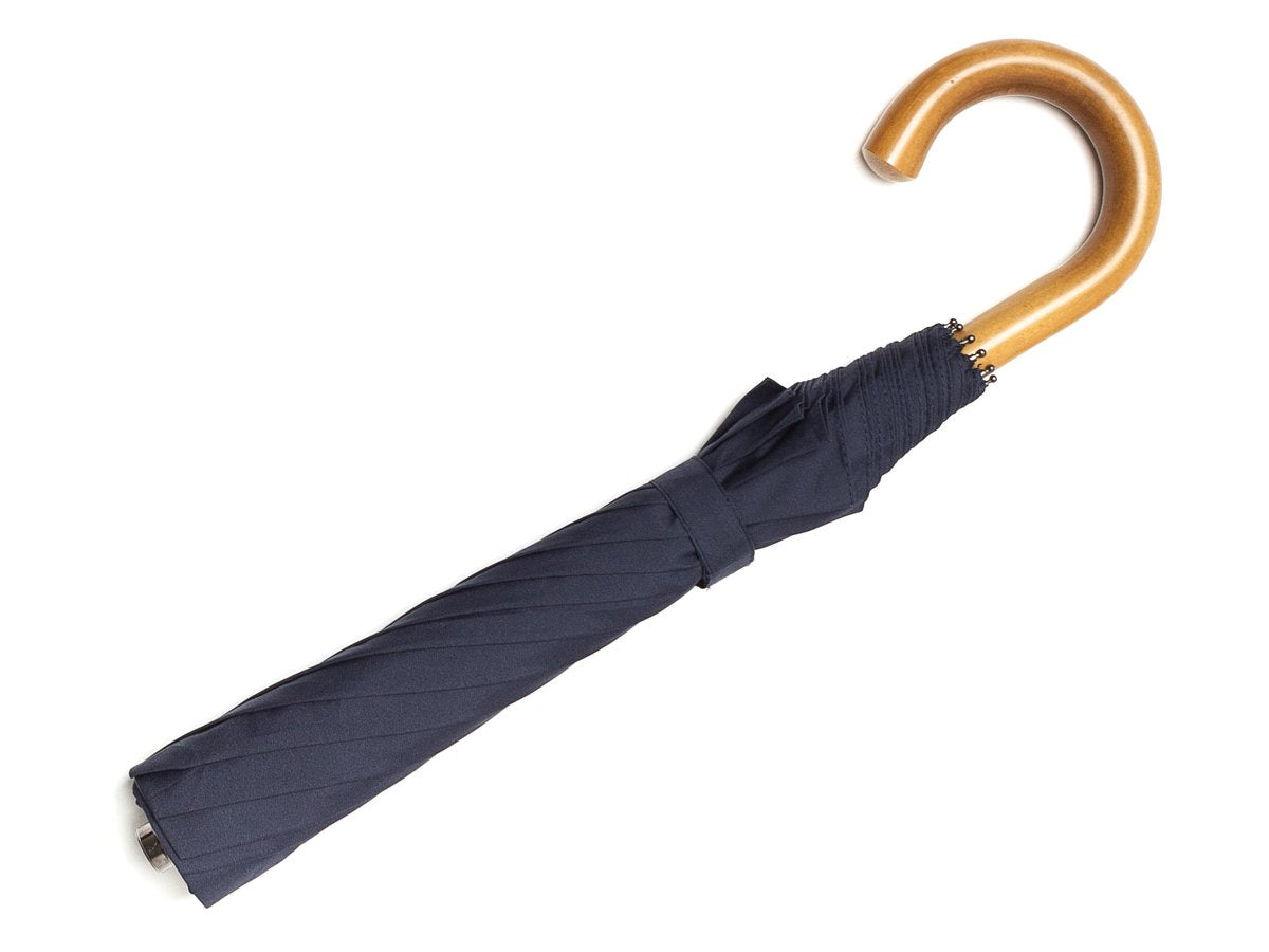 Full length view of malacca handle telescopic Fox Umbrella with navy canopy