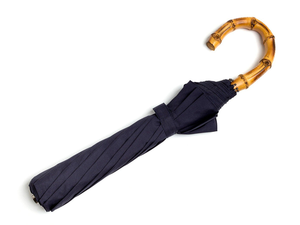 Full length view of whangee handle telescopic Fox Umbrella with navy canopy