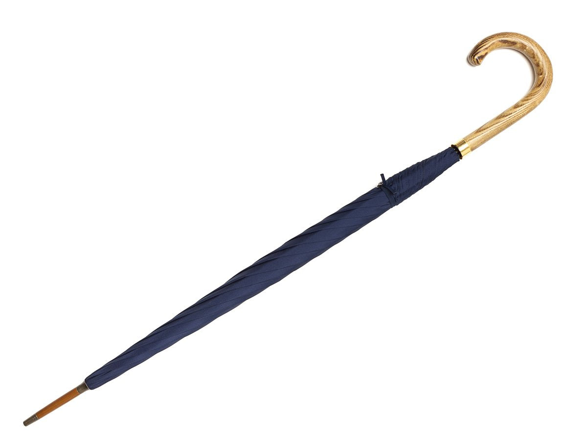 Full length view of light grain wood handle tube Fox Umbrella with navy canopy