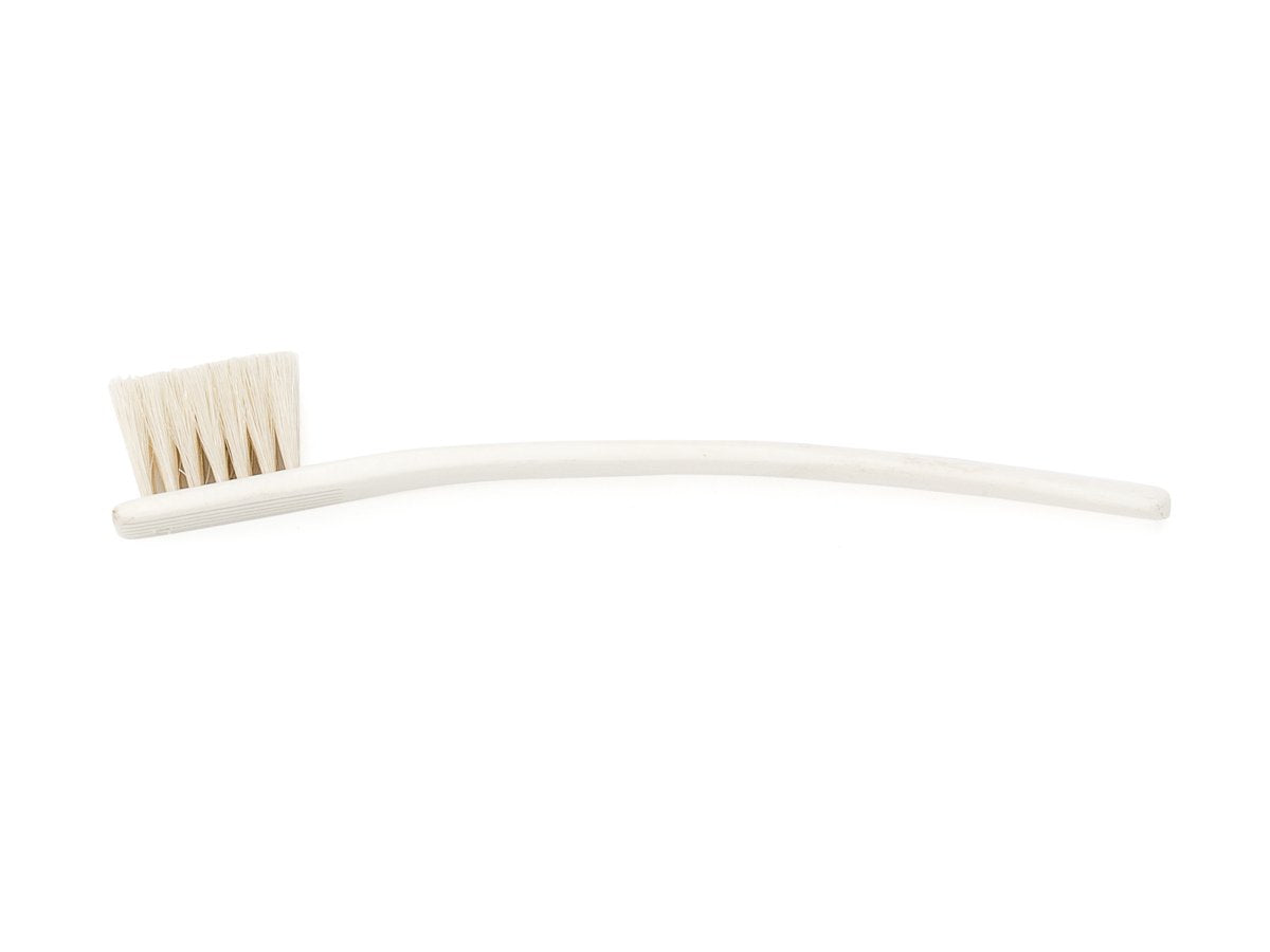Side view of toothbrush sized bone shoe polishing brush with natural bristles