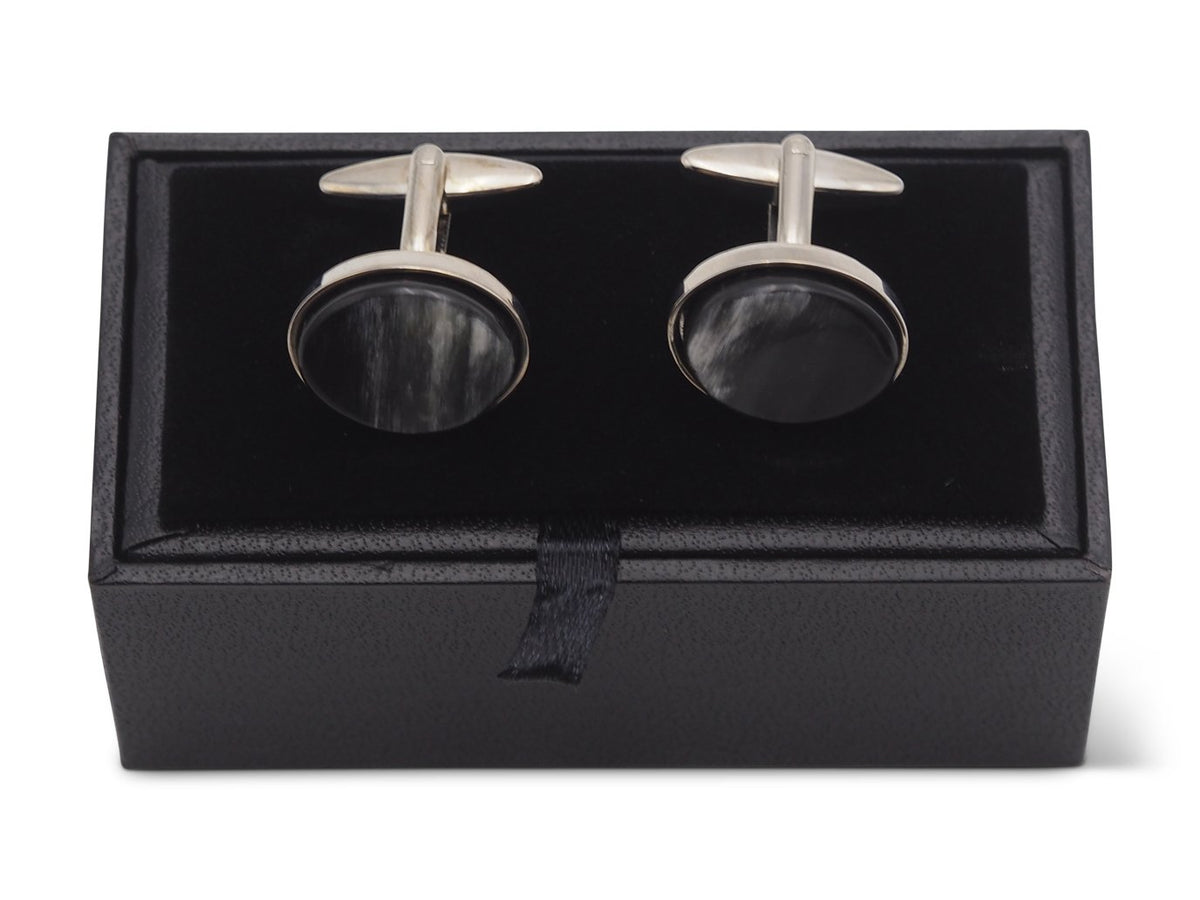 Front view of oval shaped horn cufflinks sitting on box