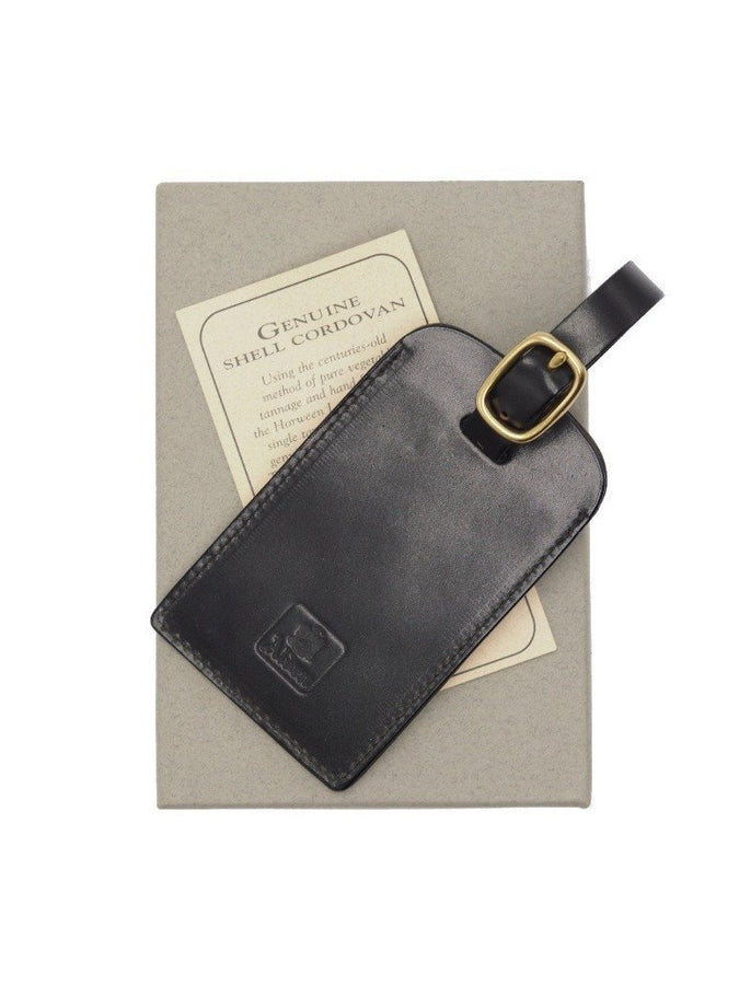 Alden luggage tag in black shell cordovan on top of box