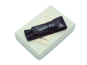 Alden pen case in black shell cordovan on top of box