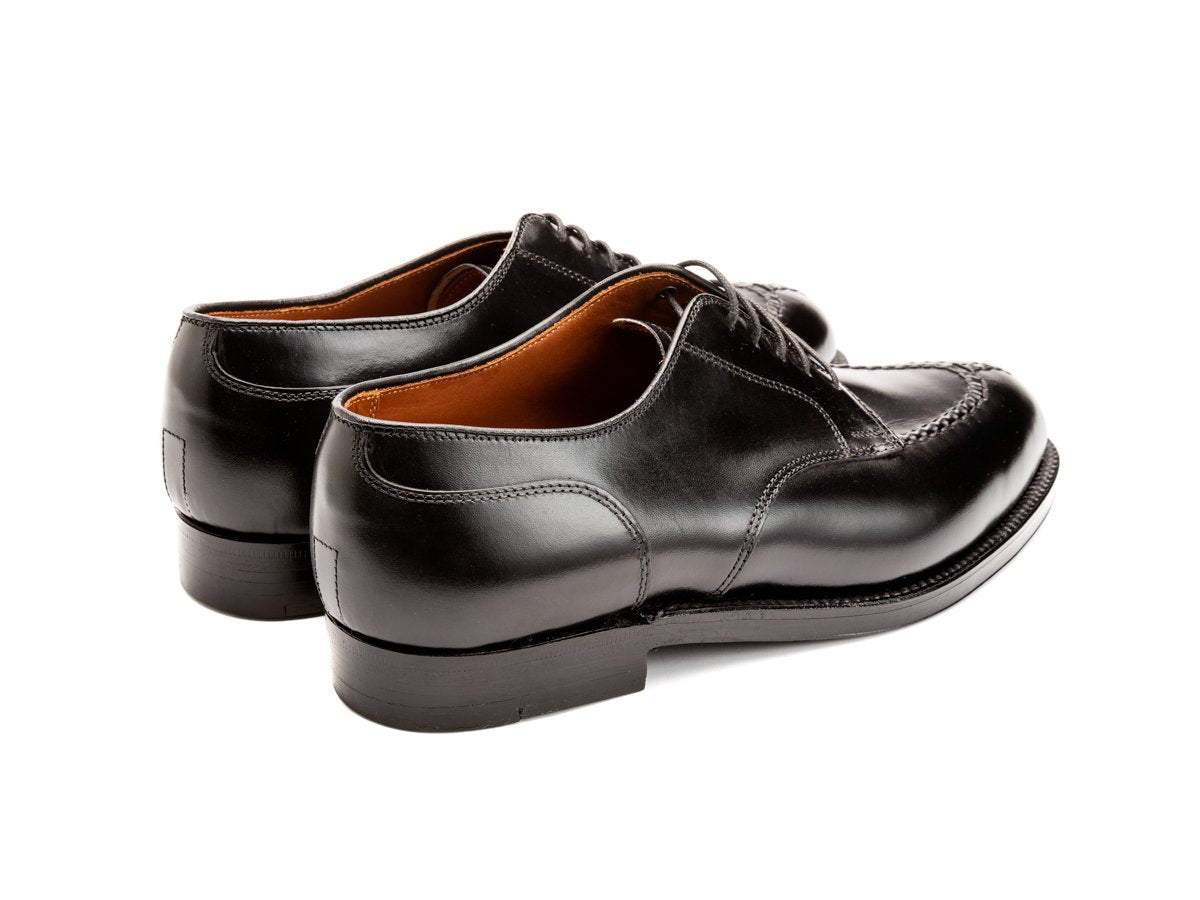 Back angle view of E width Alden Norwegian split toe blucher shoes in black calf