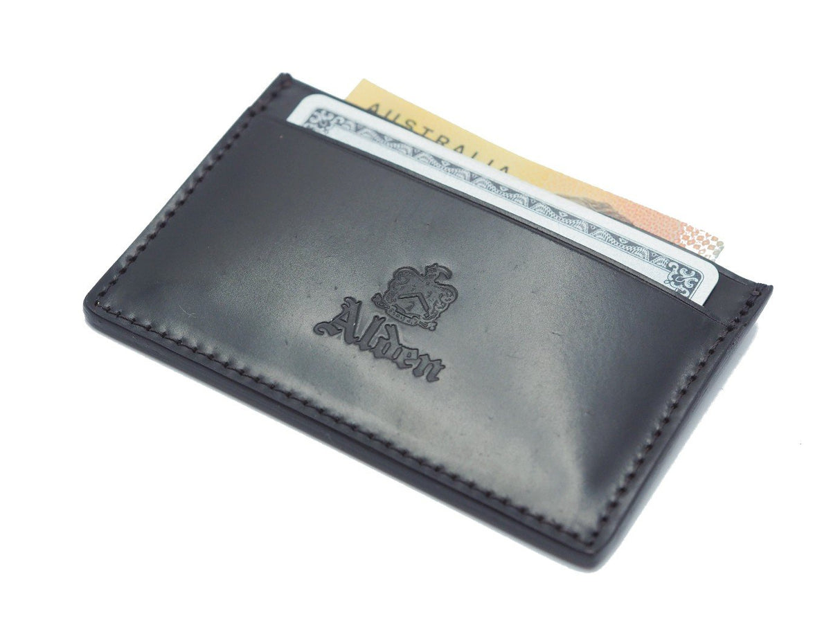 Front view of filled Alden slim credit card case in black shell cordovan