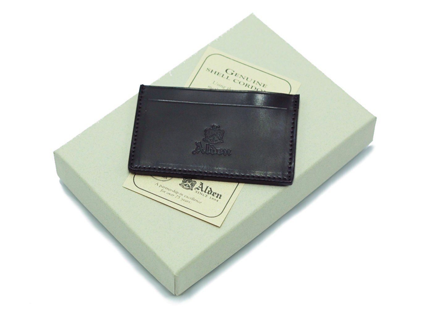 Alden slim credit card case in black shell cordovan on top of box