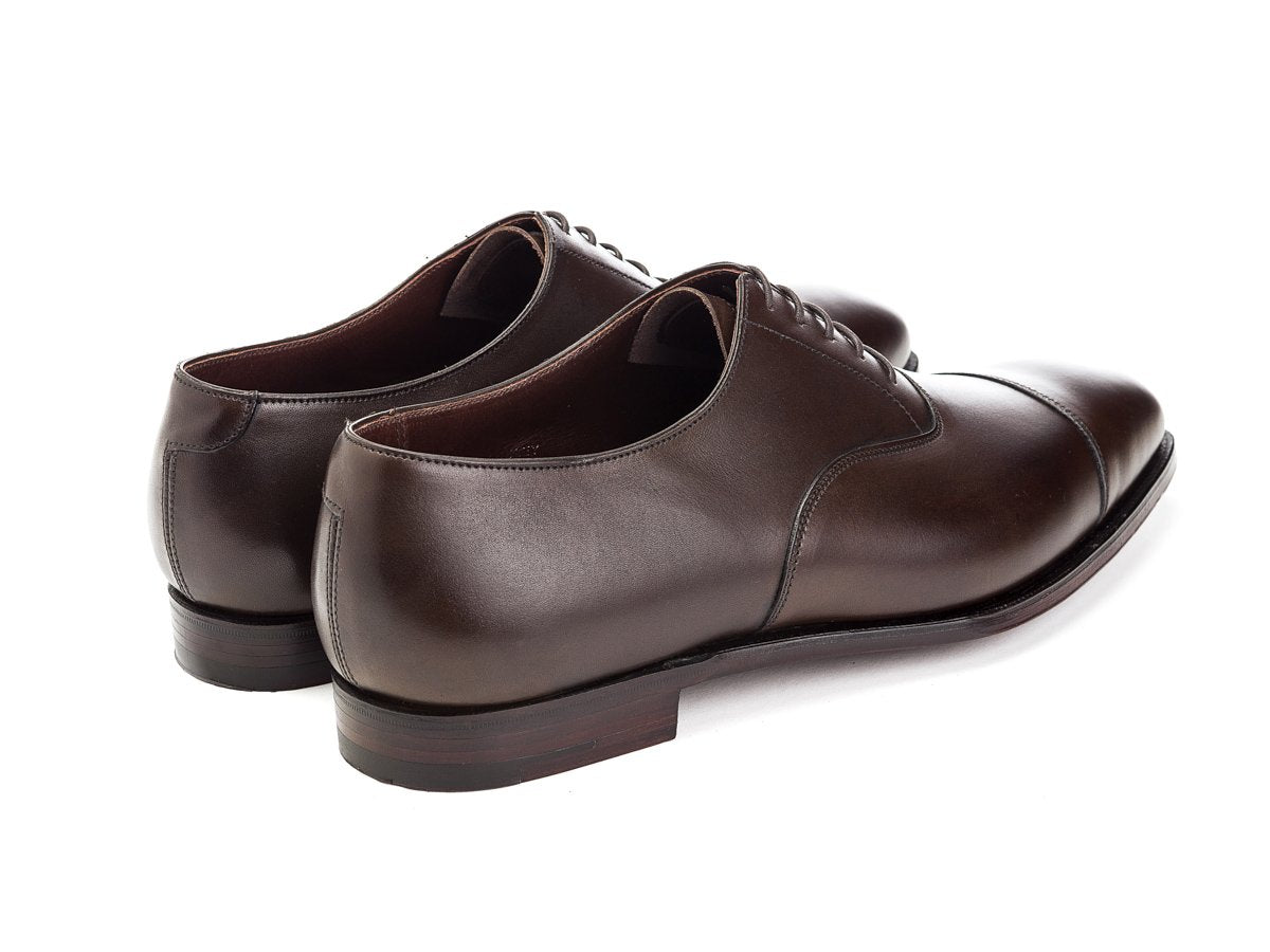 Back angle view of Crockett & Jones Audley plain captoe oxford shoes in dark brown antique calf