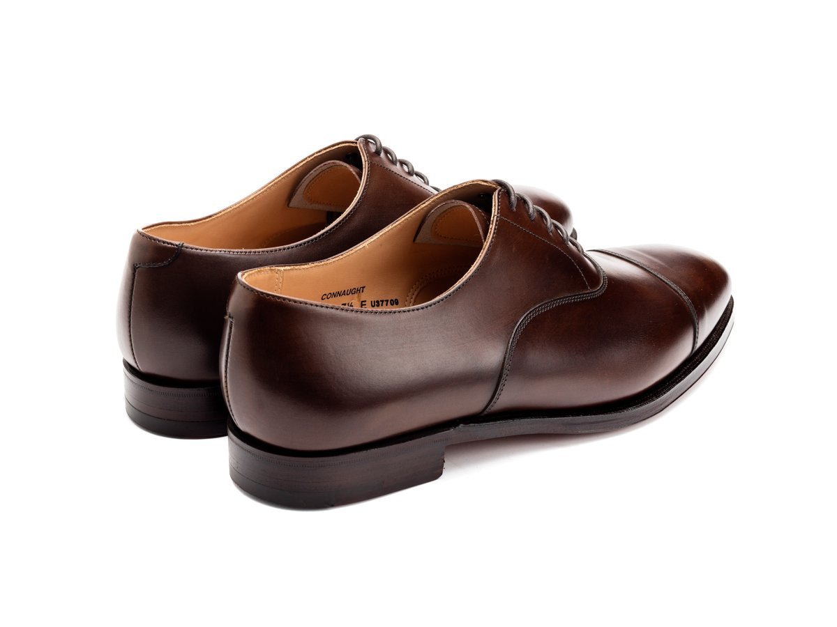 Back angle view of Crockett & Jones Connaught plain captoe oxford shoes in dark brown burnished calf