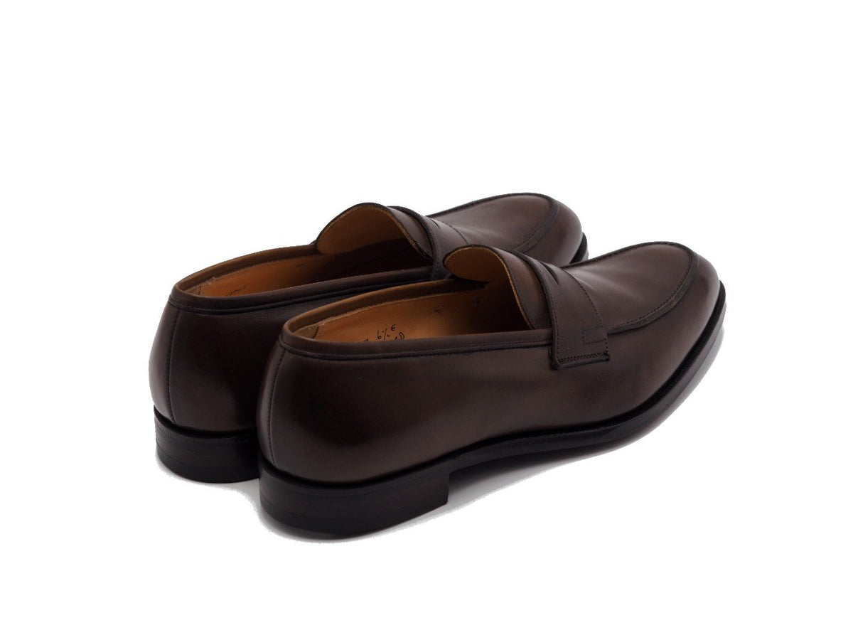 Back angle view of Crockett & Jones Crawford penny loafers in dark brown antique calf