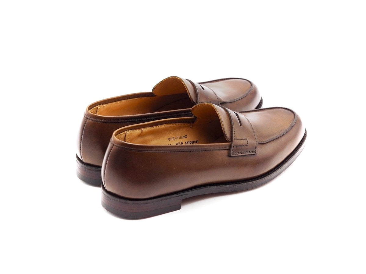 Back angle view of Crockett & Jones Grantham 2 penny loafers in dark brown burnished calf