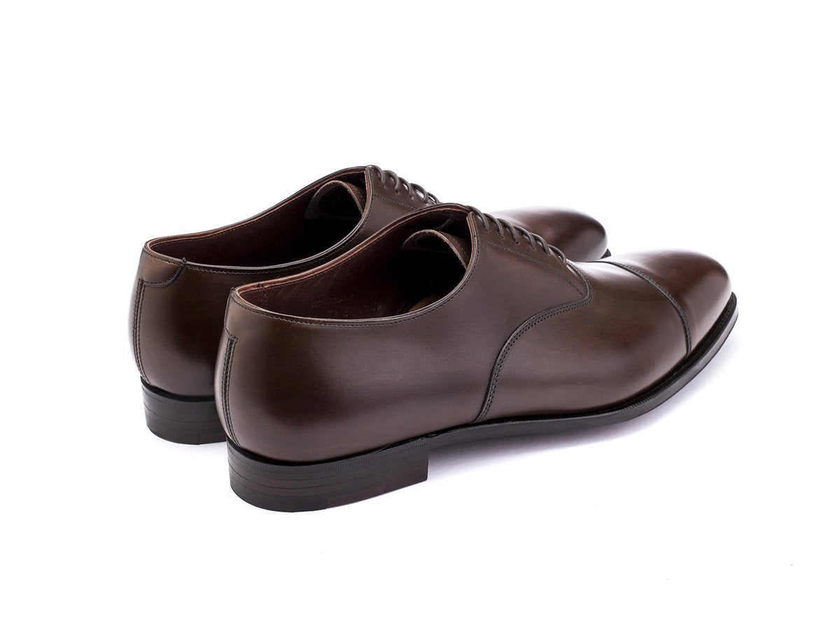 Back angle view of Crockett & Jones Lonsdale plain captoe oxford shoes in dark brown antique calf