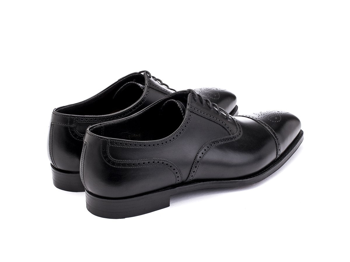 Back angle view of Crockett & Jones Selborne half brogue oxford shoes in black calf