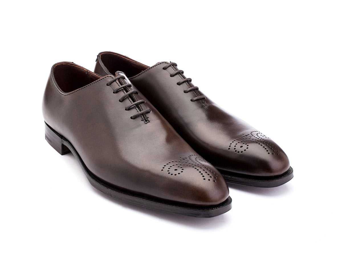 Front angle view of Crockett & Jones Weymouth wholecut medallion oxford shoes in dark brown antique calf