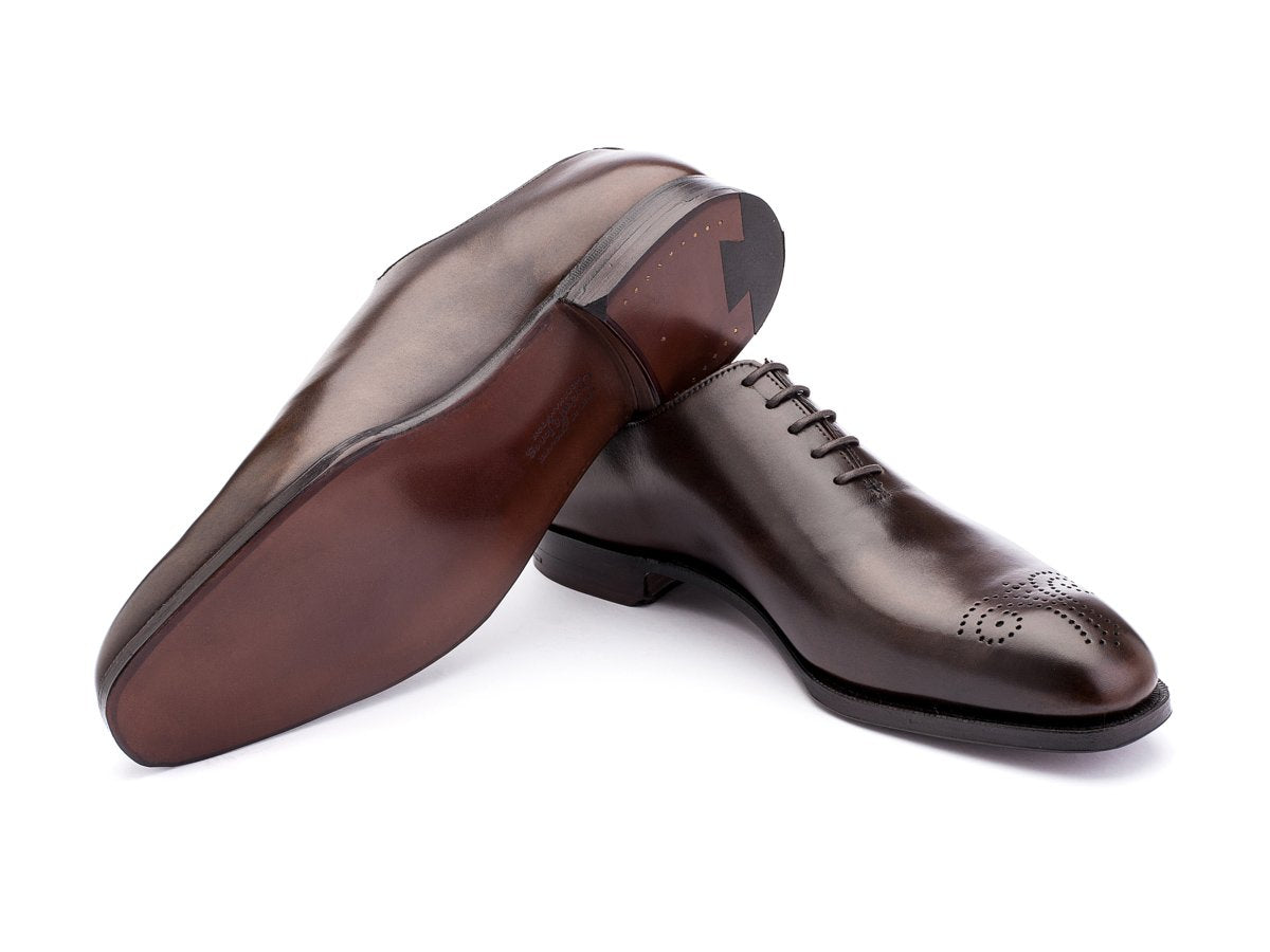 Leather sole of Crockett & Jones Weymouth wholecut medallion oxford shoes in dark brown antique calf