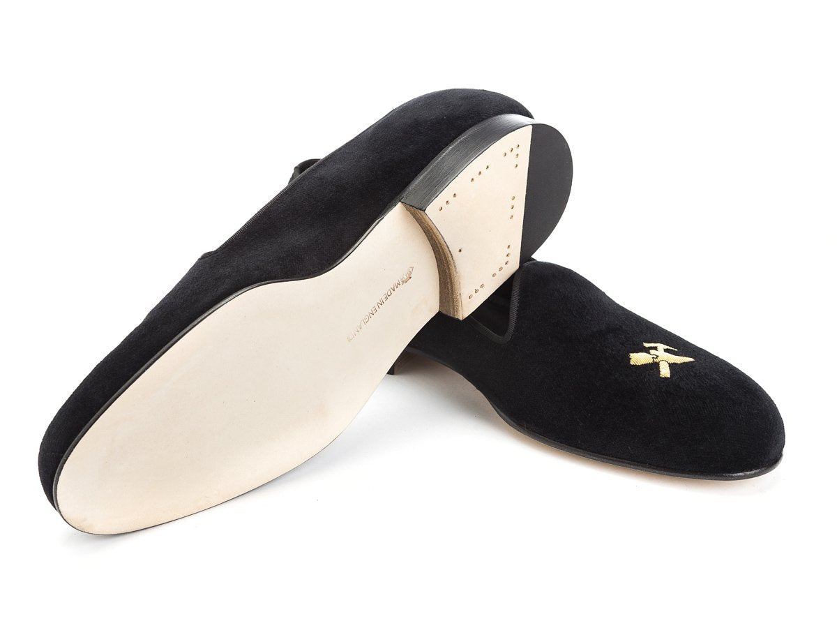 Leather sole of Edward Green Albert slippers in black velvet with hand embroidered gold Double Monk logo on toe