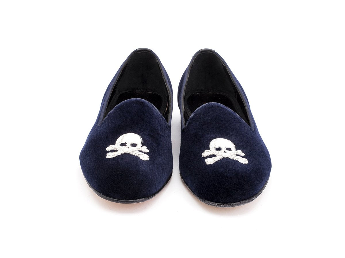 Front view of F width Edward Green Albert slippers in navy velvet with hand embroidered silver skull and crossbones motif on toe