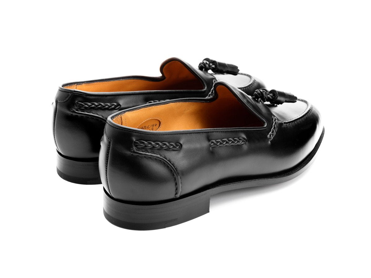 Back angle view of Edward Green Belgravia braided tassel loafers in black calf
