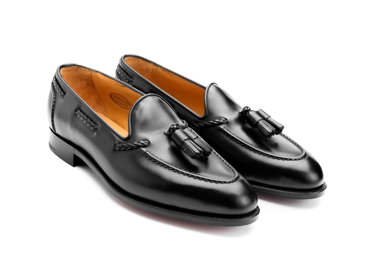 Front angle view of Edward Green Belgravia braided tassel loafers in black calf