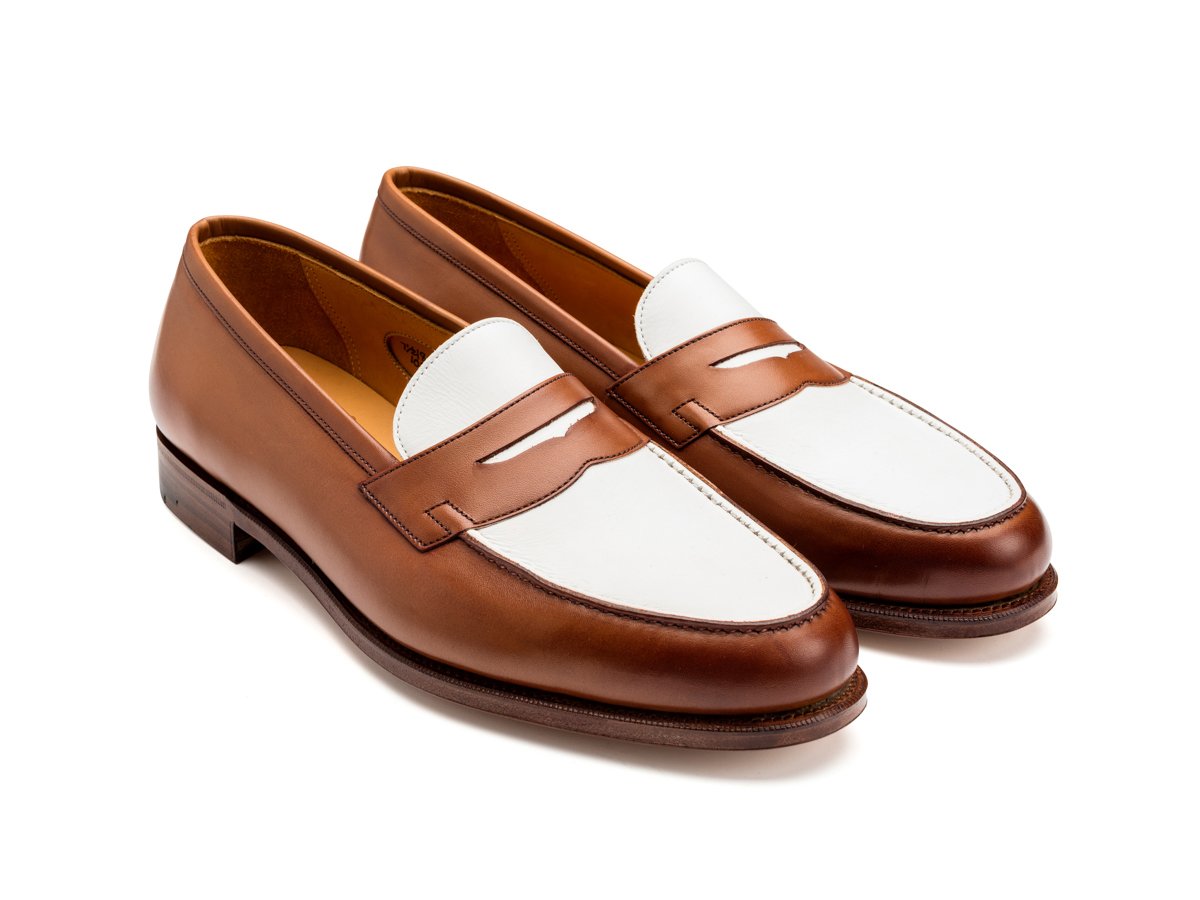 Front angle view of Edward Green Duke spectator penny loafers in hazel and white calf