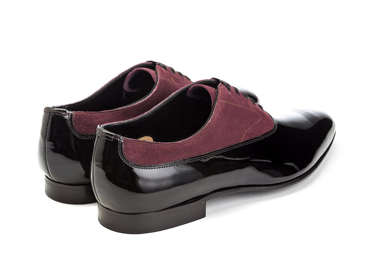 Back angle view of Edward Green Ifford plain toe balmoral oxford shoes in black patent and claret suede