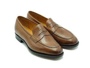 Front angle view of Edward Green Sloane split toe penny loafers in burnt pine antique calf