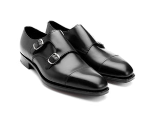 Front angle view of Edward Green Westminster plain captoe double monk strap shoes in black calf