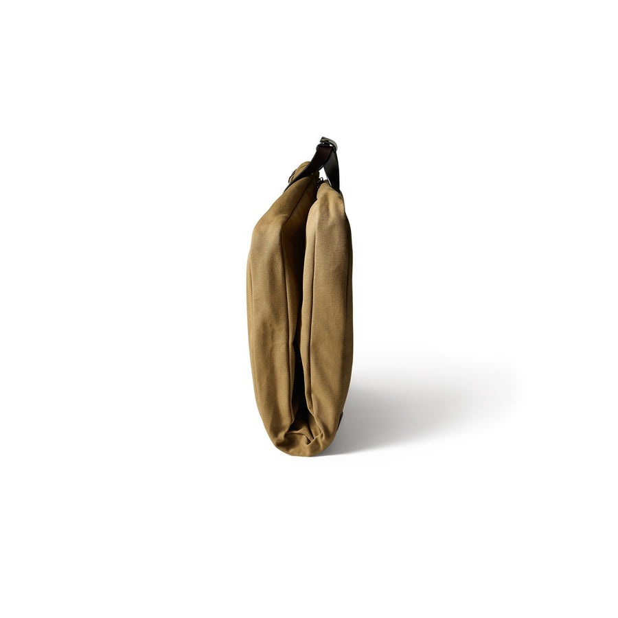 Side view of folded Filson Suit Cover bag in tan
