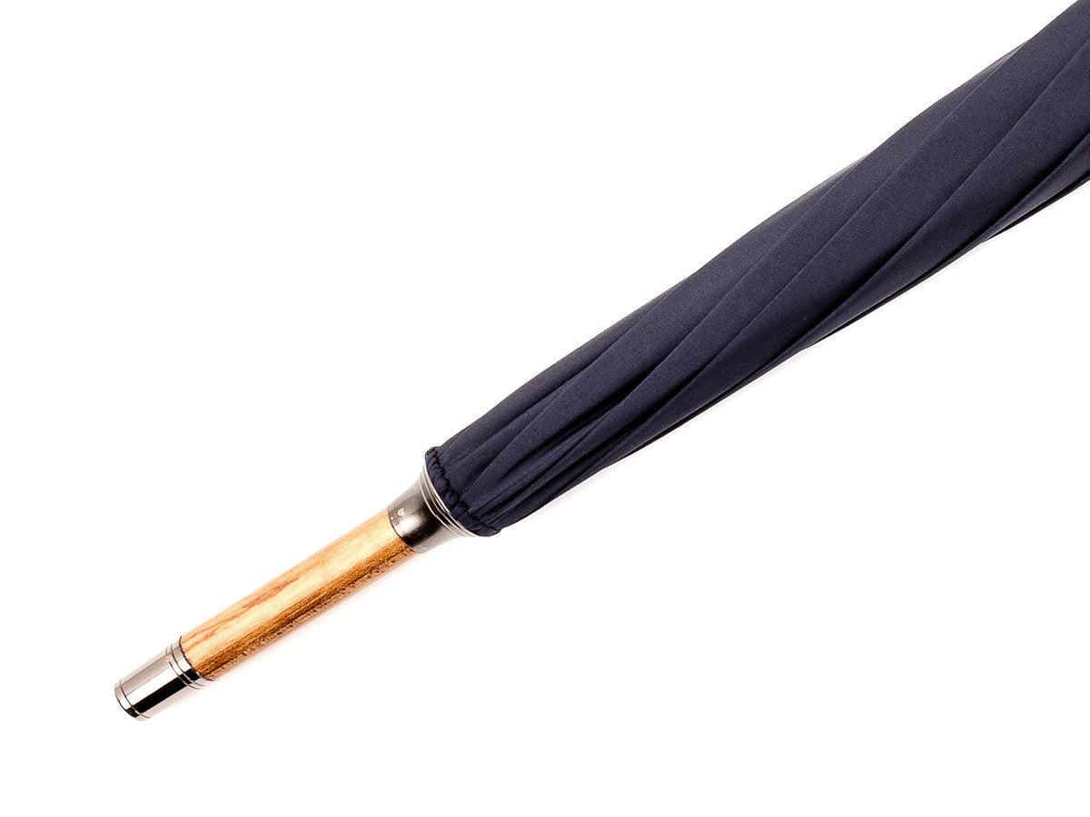 Tip end of solid scorched maple Fox Umbrella with navy canopy