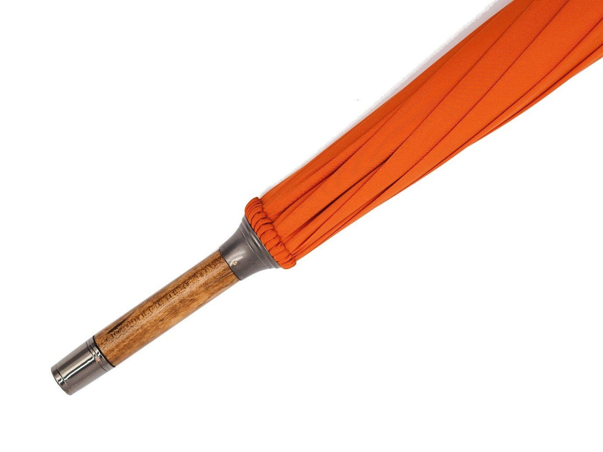 Tip end of solid scorched maple Fox Umbrella with orange canopy