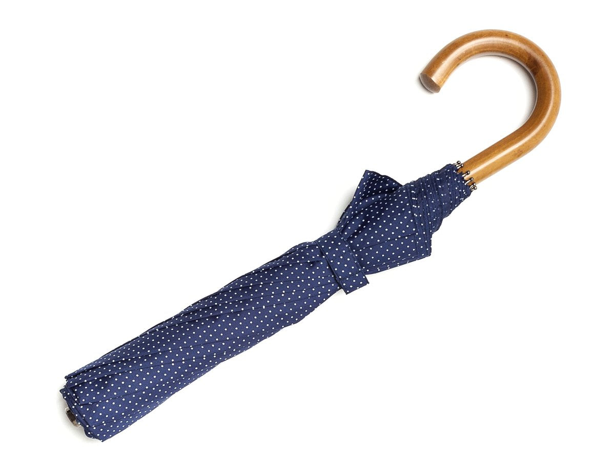 Full length view of malacca handle telescopic Fox Umbrella with navy and white polka dot canopy