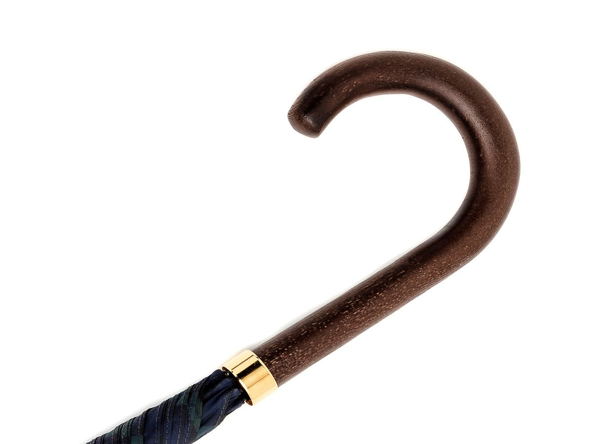 Dark brown wood handle of tube Fox Umbrella with black watch tartan canopy