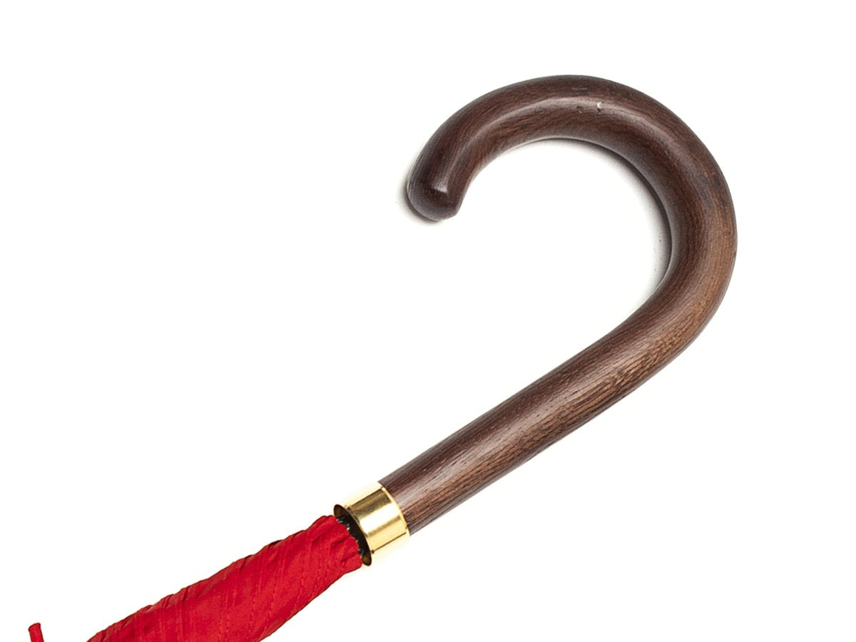 Dark brown wood handle of tube Fox Umbrella with red canopy