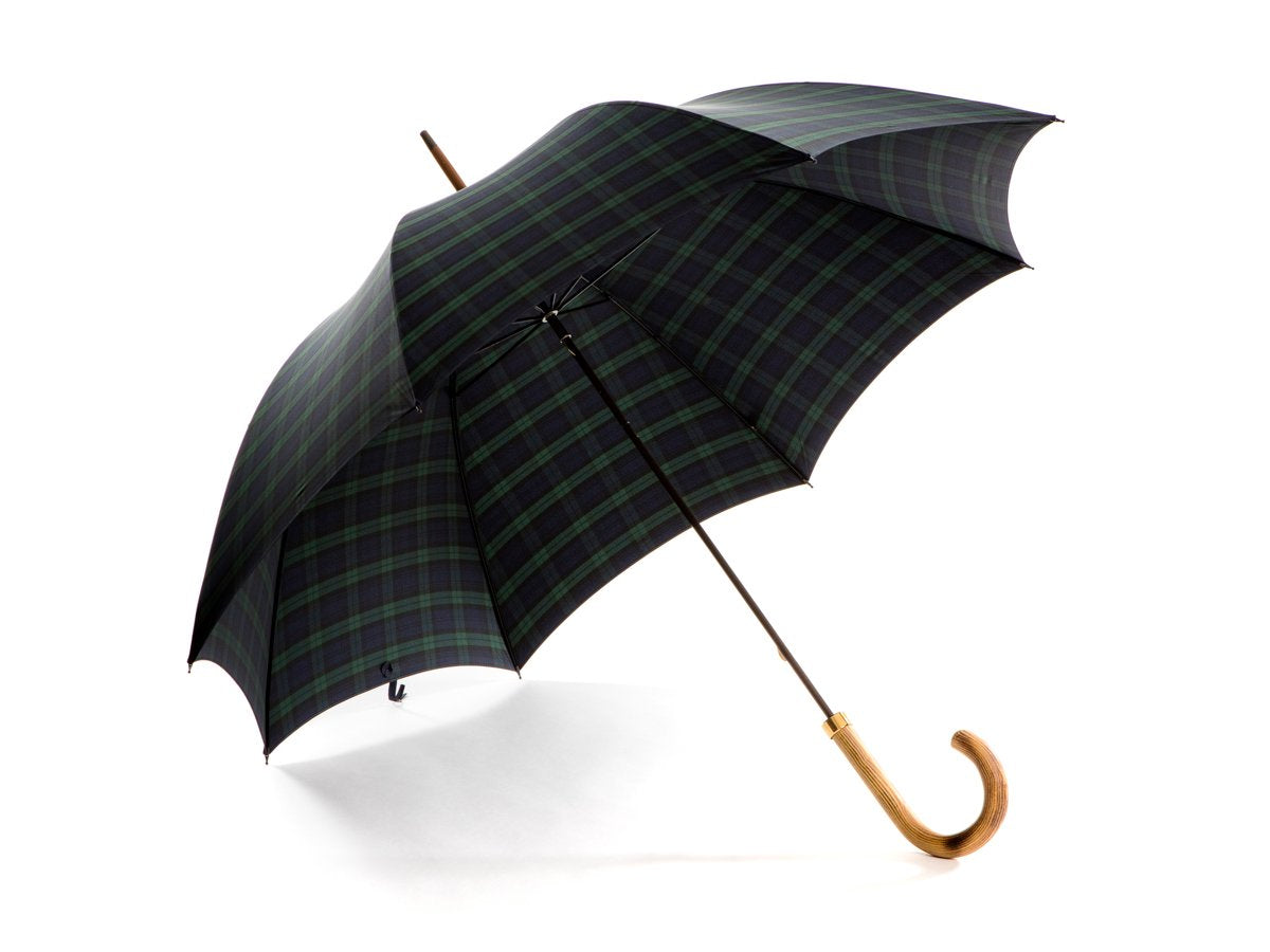 Opened light grain wood handle tube Fox Umbrella with black watch tartan canopy