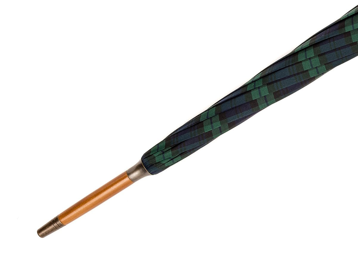 Tip end view of light grain wood handle tube Fox Umbrella with black watch tartan canopy