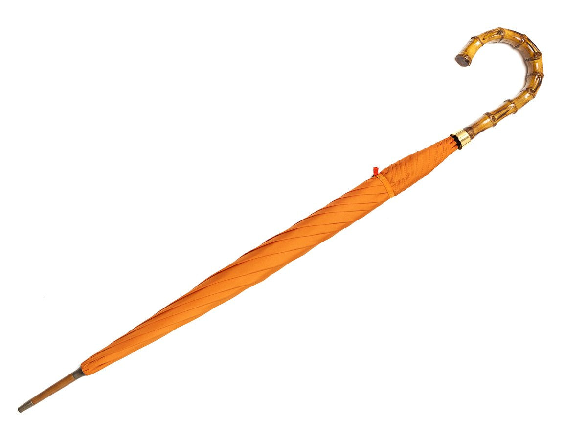 Full length view of whangee handle tube Fox Umbrella with orange canopy