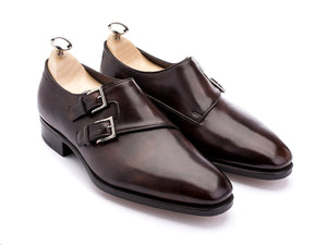 Front angle view of John Lobb Chapel plain toe swept back double monk strap shoes in dark brown museum calf with shoe trees