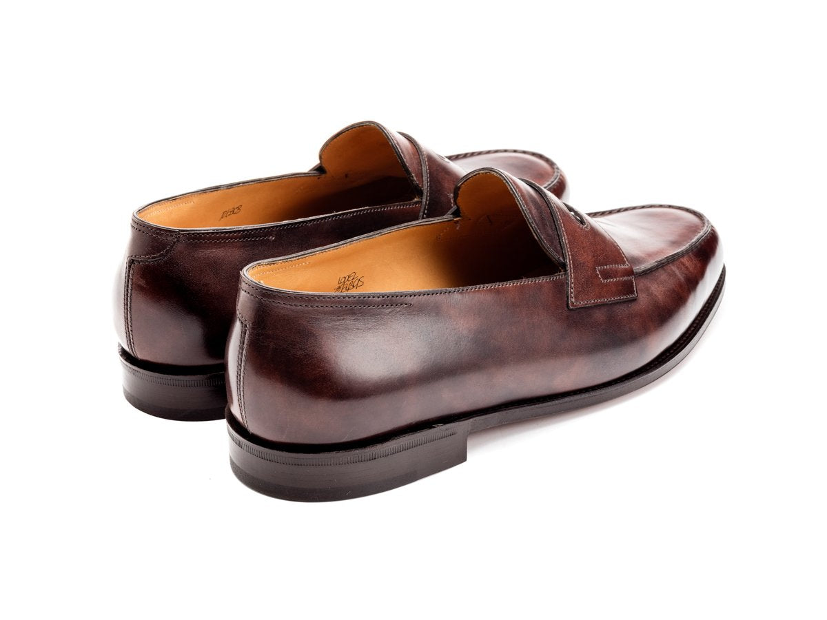Back angle view of John Lobb Lopez penny loafers in dark brown museum calf