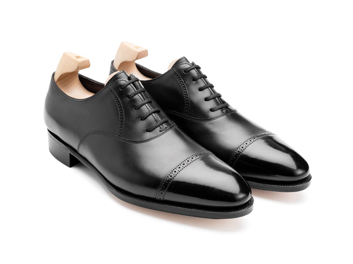 Front angle view of John Lobb Philip II quarter brogue oxford shoes in black oxford calf with shoe trees