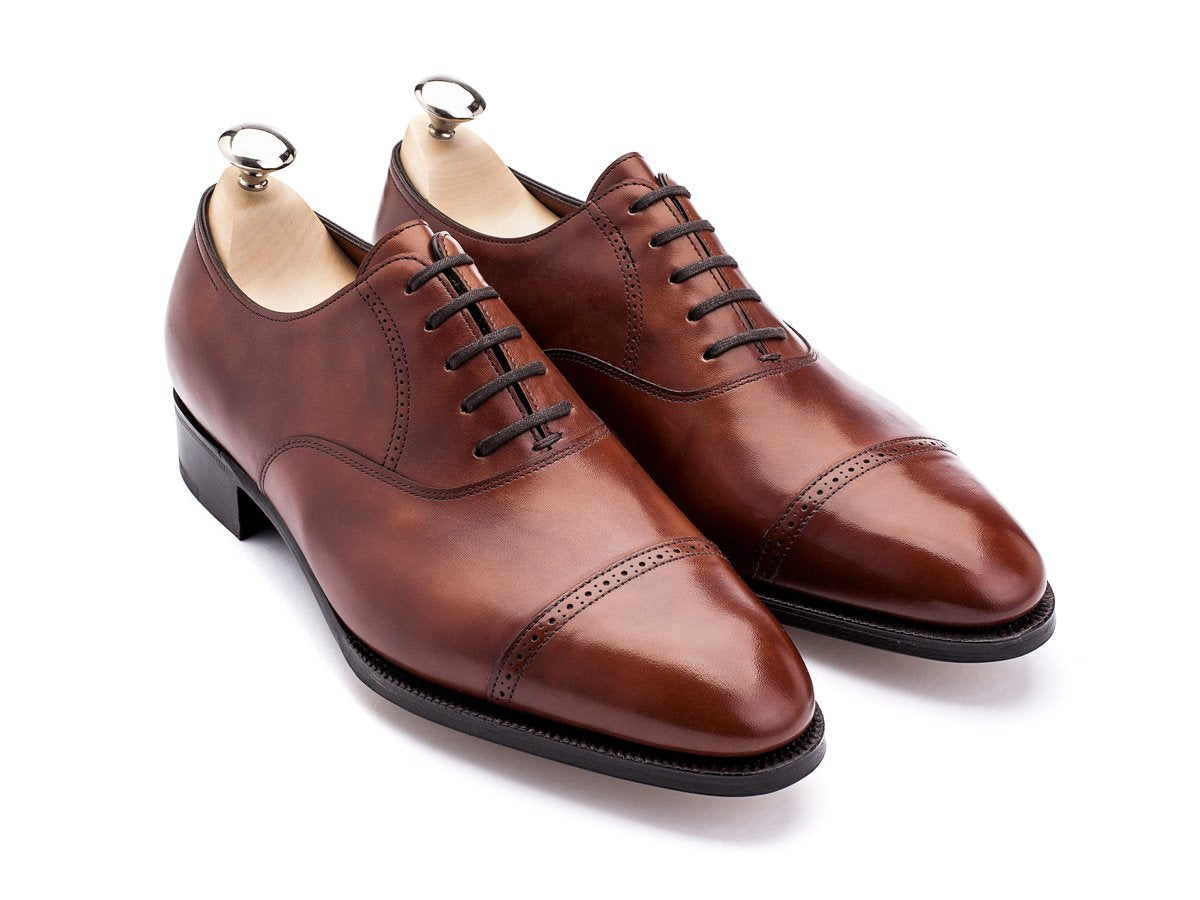 Front angle view of EE width John Lobb Philip II quarter brogue oxford shoes in chestnut misty calf with shoe trees